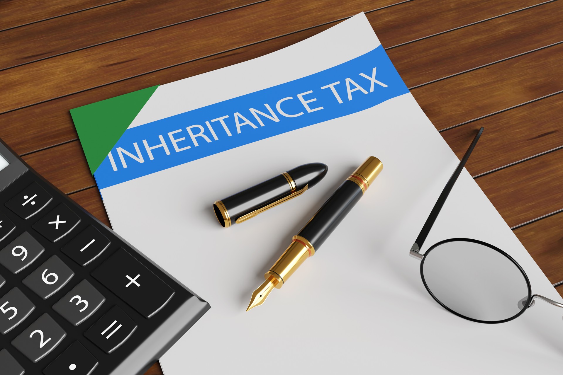 Calculator, fountain pen and spectacles on a bound document with a title inheritance tax on a wooden table